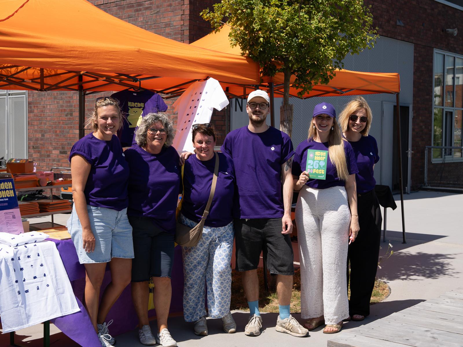 Teamfoto der Helferinnen und Helfer vor dem Spendenstand beim Sommerfest.