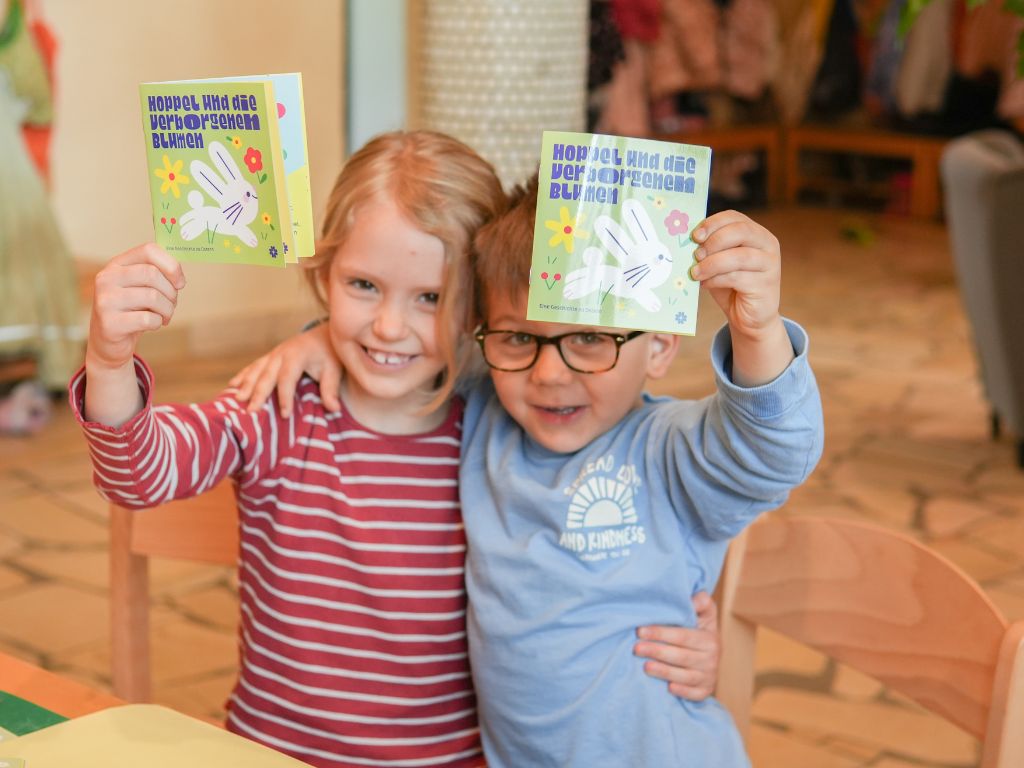 Zwei Kita-Kinder zeigen ihre Osterbüchlein von Katholino